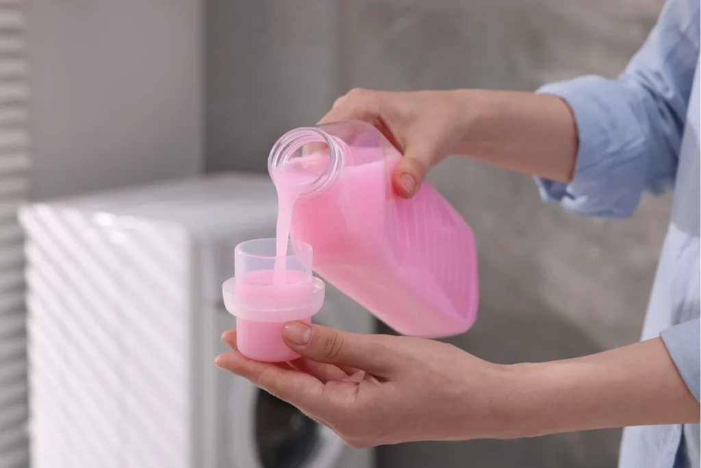 Pouring fabric softener into washing machine