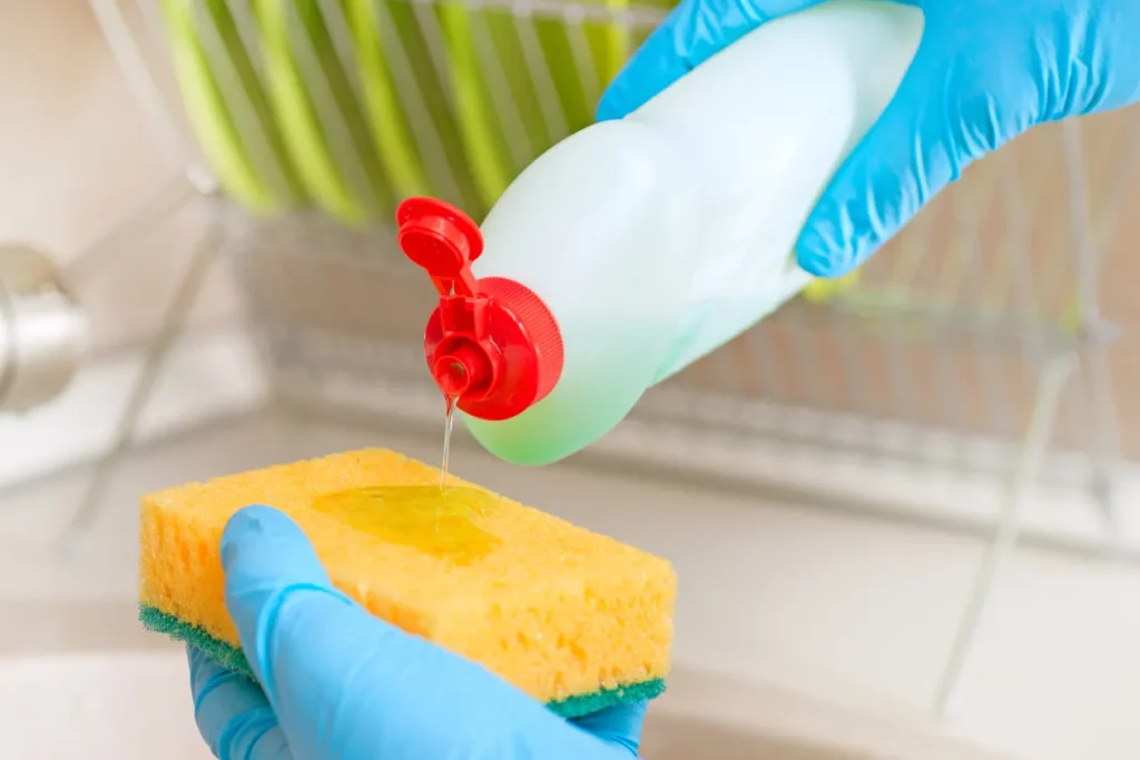 Pouring dishwashing liquid onto a washing sponge