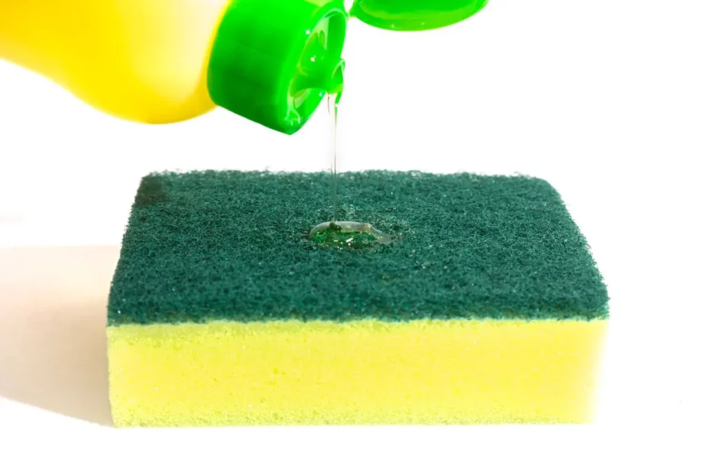 Pouring dishwashing liquid onto a washing sponge