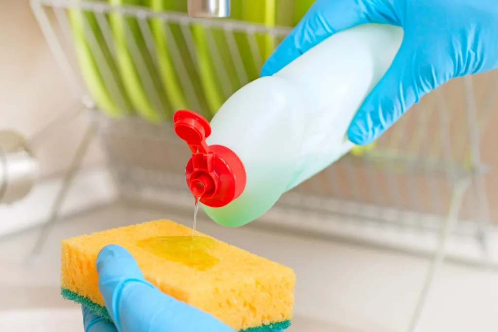 Pouring dishwashing liquid onto a sponge for washing dishes